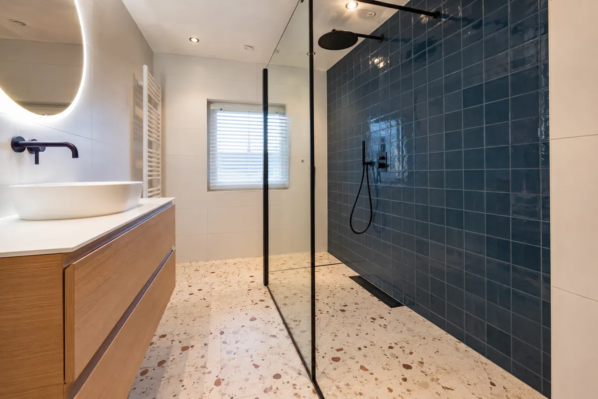 Badkamer met petrolblauwe tegelwand en terrazzovloer, Groningen